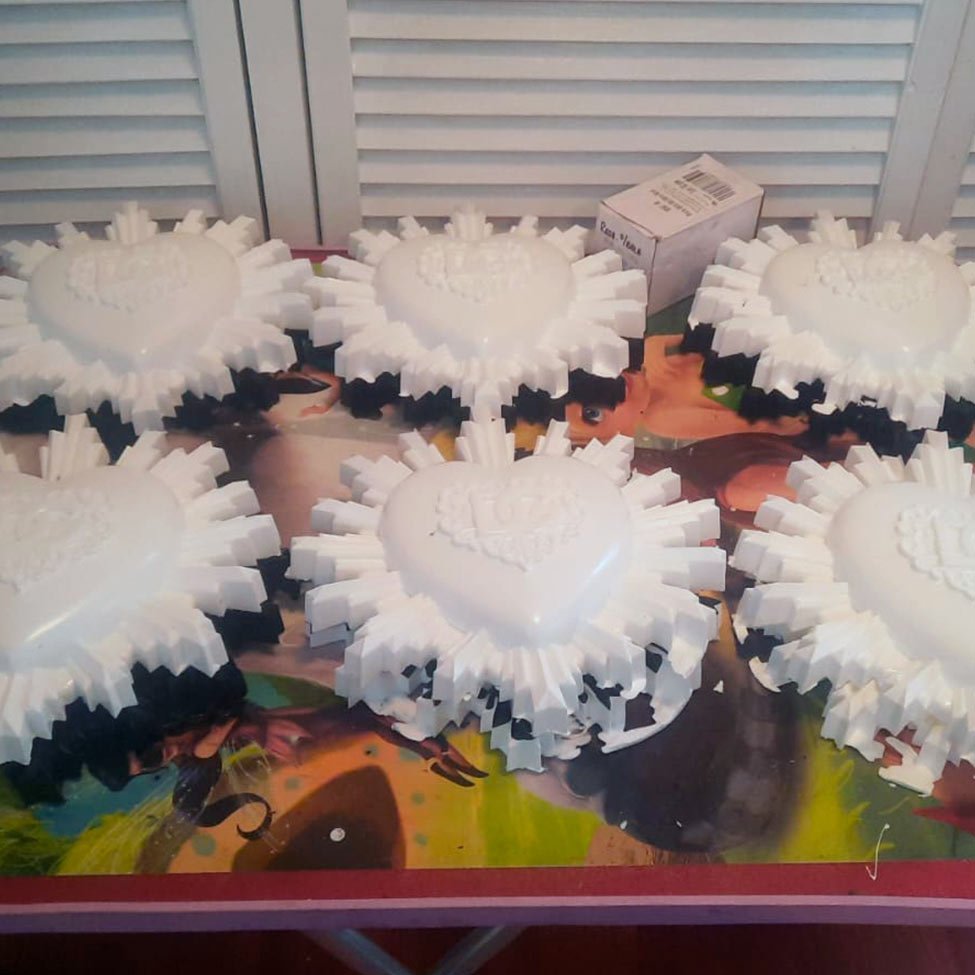 Moldes artesanales de corazón con diseño DG utilizados en la producción de piezas decorativas de Arte Plateado