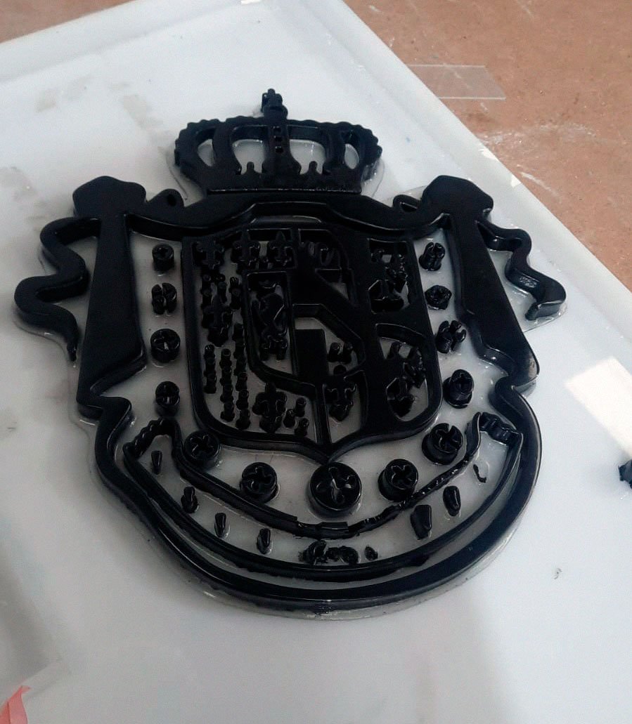 Escudo artesanal en relieve para Acqua Di Gio con acabado negro brillante, trabajo de Arte Plateado