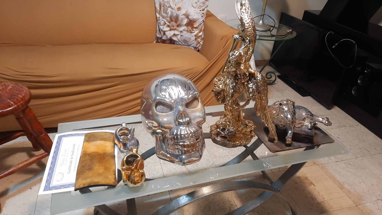 Mesa de centro con piezas decorativas metálicas en dorado y plata, trabajo artesanal de Arte Plateado